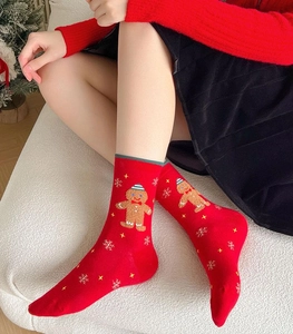 Close-up of red knit Christmas socks with gingerbread man and snowflake patterns
