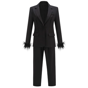 Slim black blazer and pants set with elegant feather-trimmed cuffs on sleeves