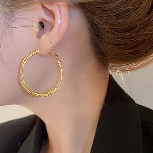 Close-up of 18k gold plated double-layer hoop earrings worn by a female model