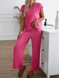 Detailliertes pinkes Strickset mit Kurzarm-Oberteil und weiter Hose für Damen im Fokus
