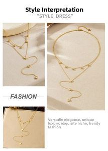 Close-up of double-layered gold stainless steel Y-necklace with crystal heart pendants