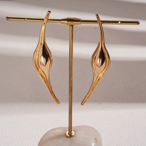 Modern irregular abstract fluid gold geometric stud earrings on a T-bar display stand