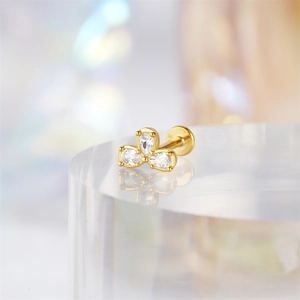 Detailed view of 16G gold clover earring with clear gemstones on an acrylic stand