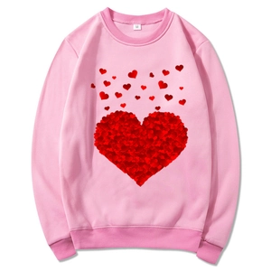 Pink crew neck sweatshirt with red heart floral graphic print in a flat lay style