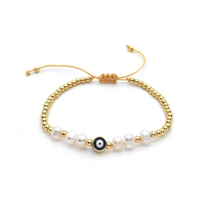 Baroque pearl bracelet with gold beads and evil eye charm on adjustable cord