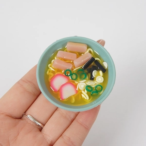 Hand hält eine 5cm Miniatur-Ramen-Schale mit detaillierten Nudeln und Beilagen