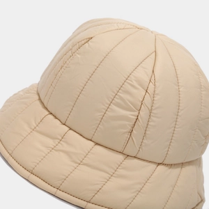 Close-up of beige quilted fisherman hat with detailed stitching and windproof fabric texture