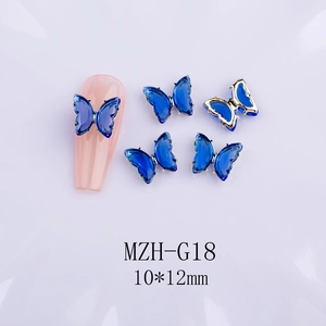 Detail view of 10x12mm blue crystal butterfly nail charms with golden metal base