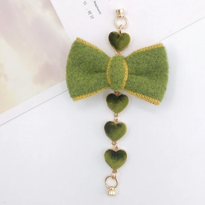 Detail of green plush bow and gold chain with heart gems for DIY jewelry making