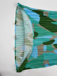 Détail macro d'une robe plissée avec imprimé camouflage moderne en vert et bleu azur