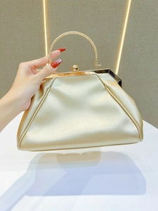 Detailed view of the gold evening clutch featuring textured metal handle and ball clasp