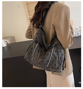 Close-up of grey tote bag with black polka dots and butterfly embroidery detailing