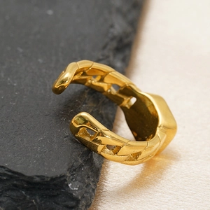 Detail of 18k gold plated stainless steel Cuban chain link open ring on stone background