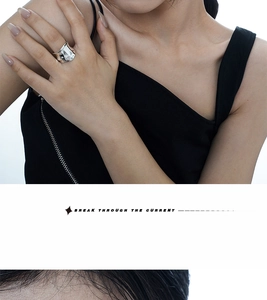Detailed close-up of textured origami style wide silver ring on model's hand