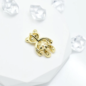 Golden bear pendant with sparkling crystals on a clean white geometric display stand