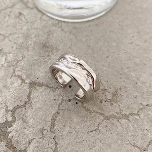 Minimalist S925 sterling silver open ring with irregular rock texture on grey concrete