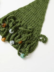 Détail macro du tricot vert avec des perles décoratives colorées élégantes