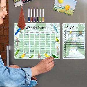 Detailed view of magnetic weekly planner on fridge with tropical leaf and bird design