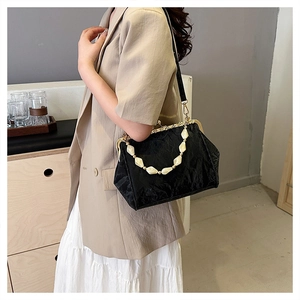 Chic black pleated shell bag with white pearl handle and gold metal clasp on model