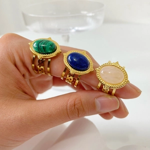 Close-up of vintage gold stainless steel rings set with colorful natural stones on hand