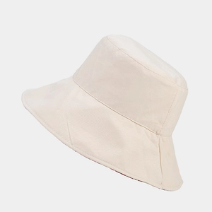 Detail of cream cotton bucket hat showing precise stitching and red floral lining fabric