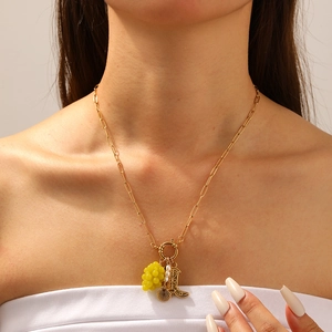 Collana in acciaio dorato con ciondoli a forma di uva, conchiglia e stivale su chiusura