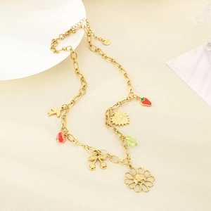 Golden stainless steel necklace with floral, strawberry, and cherry pendants on a beige base