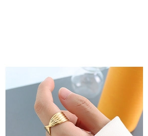 Close-up of a gold-plated twisted ring with vertical stripes on a model's thumb
