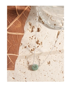 Macro detail of geometric green jade ring pendant on a refined S925 sterling silver chain