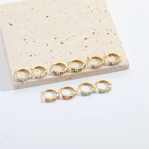 Detail view of gold hoop earrings featuring multicolor zircon devil's eye square charms