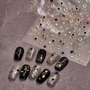 Star themed nail stickers with gold and black designs on black and silver nails
