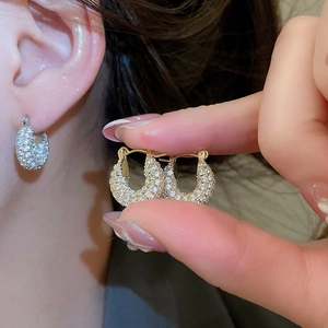 Close-up of gold plated U-shaped hoop earrings with sparkling pave-set cubic zirconia