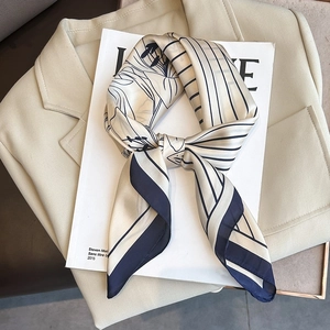 Elegant beige striped silk square scarf with floral print on white magazine and blazer