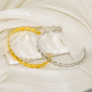 Detailed view of polished gold and silver heart-shaped adjustable open bangles