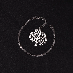 Detail of silver tree of life necklace with heart-shaped leaves on black background