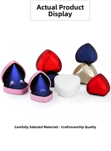 Macro shot of heart-shaped LED ring boxes with diamond-cut texture and spot lighting