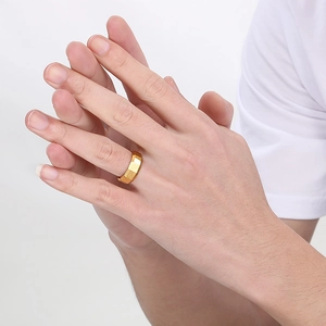 Close-up of 8mm gold brushed faceted stainless steel geometric ring on a finger
