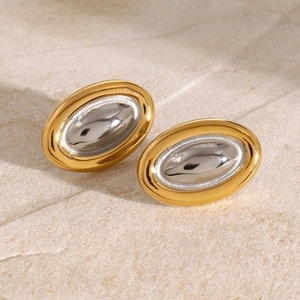 Oval two-tone 18k gold and silver stainless steel earrings on textured stone base