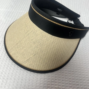 Detail of woven straw texture and black elastic headband with metal G-buckle accent
