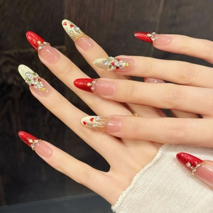 Christmas press-on nails featuring red glitter, 3D pearls, and rhinestone tree designs