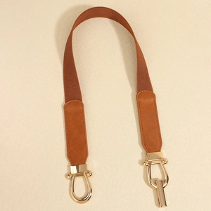 Detail of a brown elastic waist belt with a golden U-shaped metal buckle and PU leather