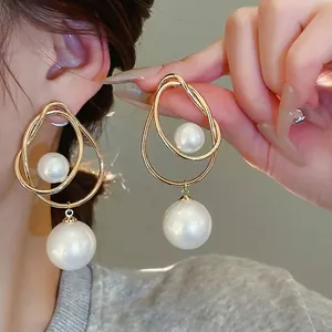 Boucles d'oreilles créoles torsadées dorées avec perles élégantes pour un look moderne