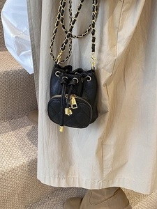 Mini black quilted bucket bag with drawstring closure and golden chain crossbody strap