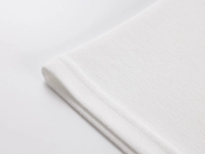 Close-up of high-quality white knitted fabric showing delicate texture and neat stitching