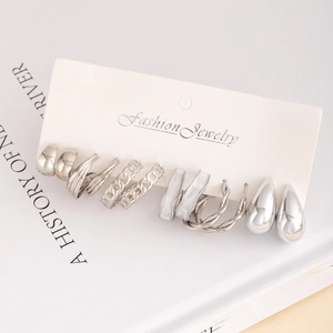 7-pair minimalist silver C-shaped hoop earrings set on a white fashion jewelry card