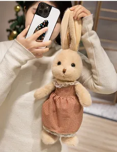 Dettaglio del coniglietto di peluche con vestito a quadretti rossi e pizzo e lunghe orecchie