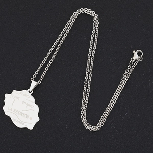 Macro view of La Réunion map pendant with detailed city engravings on silver chain
