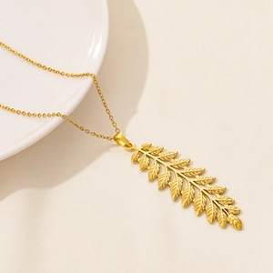 Detailed close-up of a gold stainless steel leaf pendant on a delicate cross chain