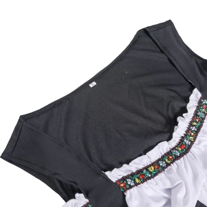 Detail view of the embroidered black neckline with white ruffles and floral lace patterns