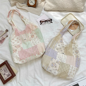 Dettaglio di borse tote trapuntate con patchwork floreale ed etichetta Sozakka su tessuto
